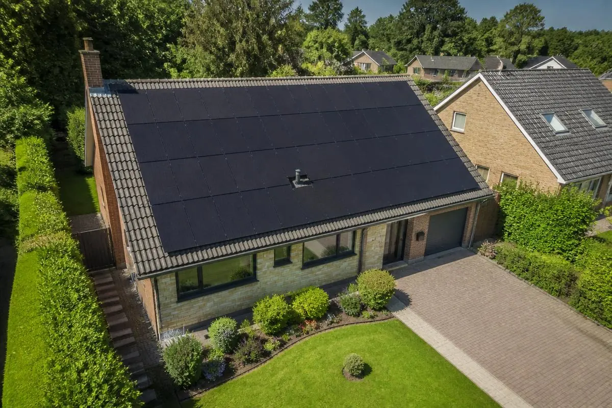 Aerial view of black solar panels covering a house roof in Essex