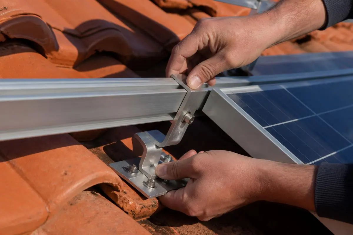 Engineer fitting solar mounting rails to roof tiles